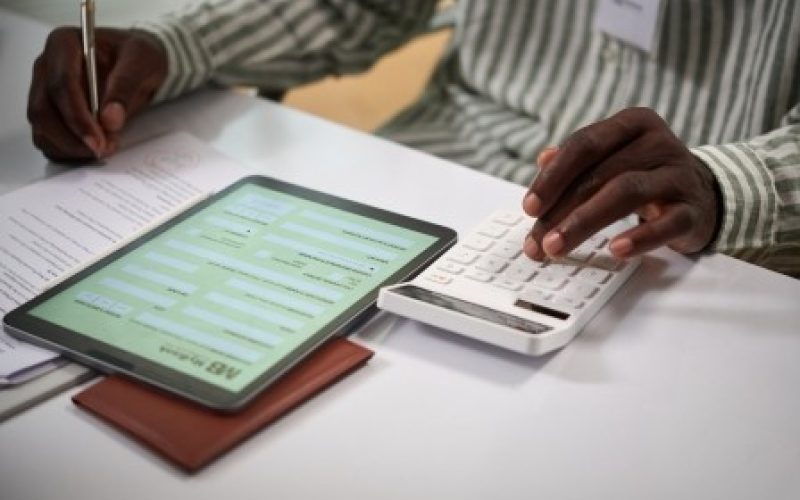 Bank manager helping client to calculate sum of down payment